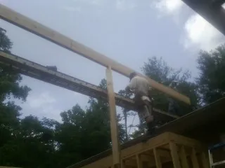 Carpenter setting a ridge beam over a new addition frame — Ice Dam Removal by Roofing Brothers in Otley