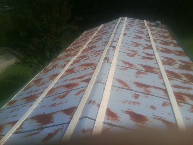 Rusted metal roof panels with new wood purlins before replacement — Storm Damage Roof Repair in Otley by Roofing Brothers