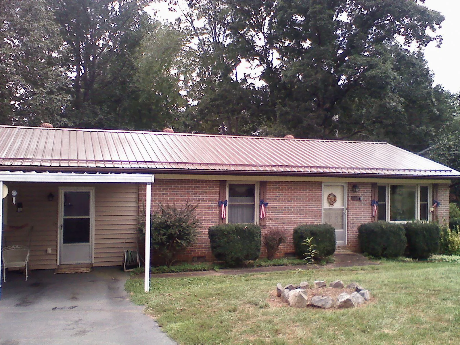 Bronze metal roof and carport on a brick ranch home — Roof Repair work by our crew in Otley